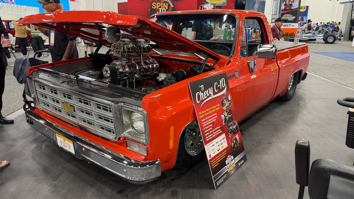 Red supercharged Chevy C10 pickup truck on display at SEMA 2025