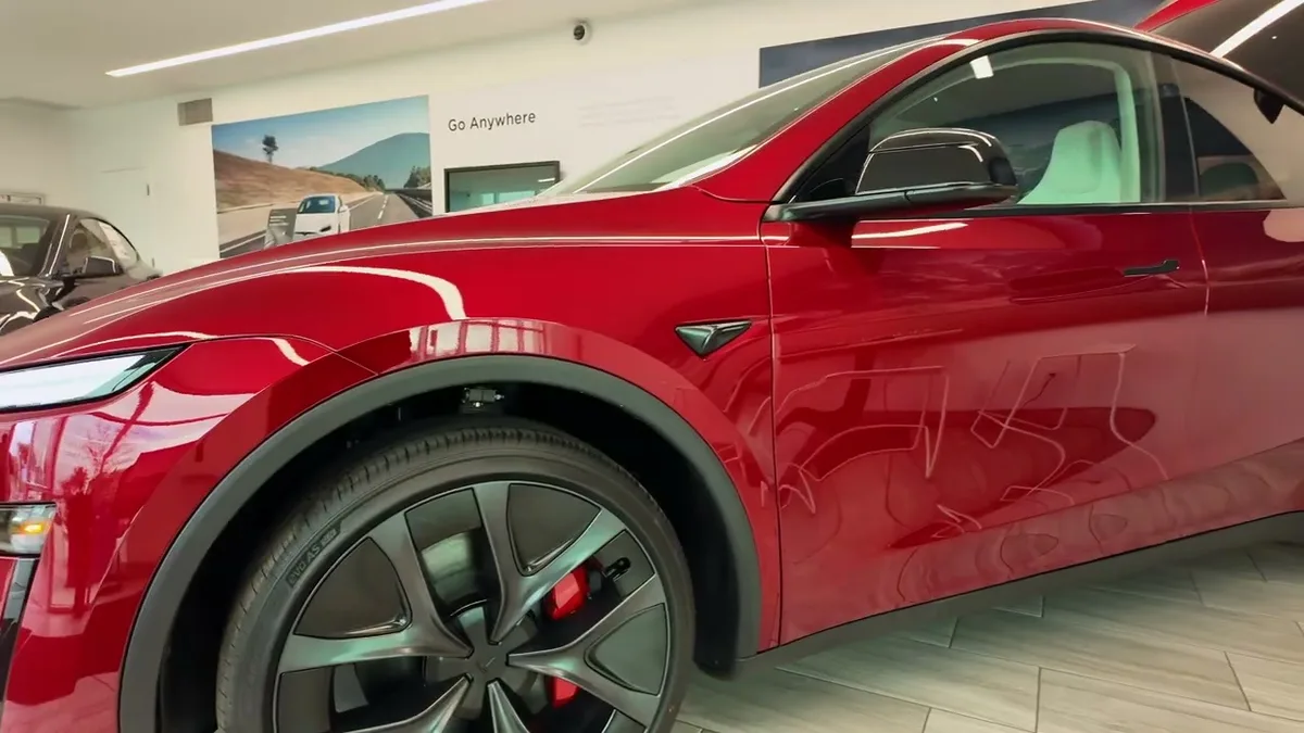 Close-up of the 21-inch staggered wheel with red brake caliper on the Model Y Juniper Performance