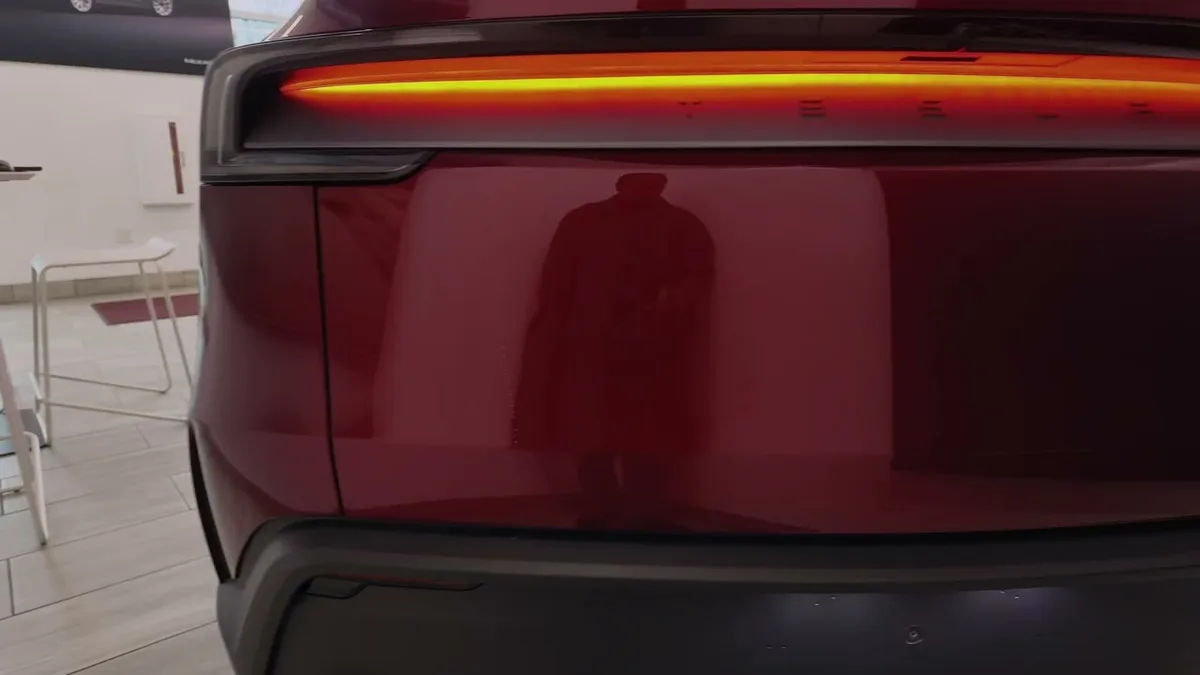 Model Y Juniper Performance rear taillight bar glowing orange-red with carbon spoiler visible