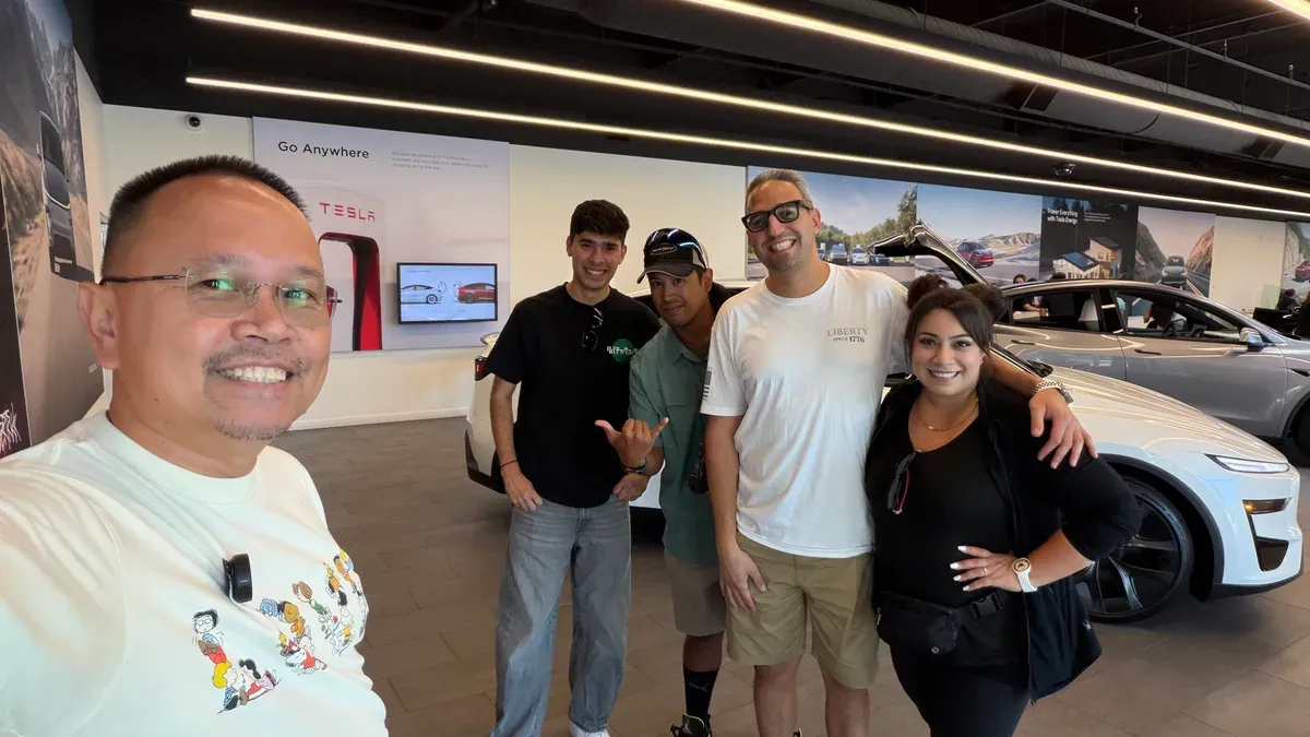 Sherwin and four other Tesla owners taking a group selfie inside the Riverside Tesla showroom.