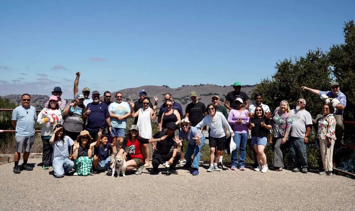Rivian owners club group photo at a hilltop overlook