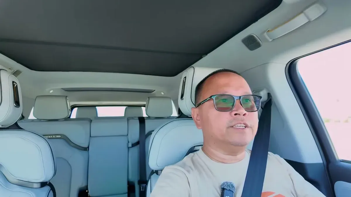 Driving the Rivian R1S after installing the roof shade, with dark headliner visible