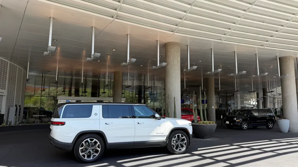 White Rivian R1S parked at the Vdara hotel porte-cochère under modern architecture