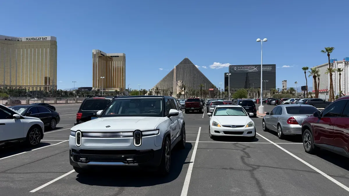White Rivian R1S Gen 2 parked in a Las Vegas lot with the Luxor pyramid and Mandalay Bay visible behind it