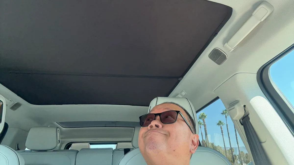 Looking up at dark fabric roof shade installed in Rivian R1S