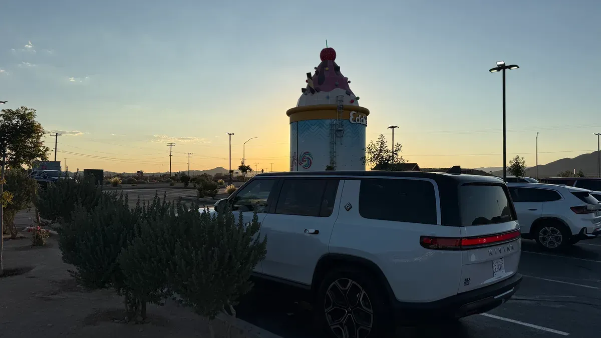 White Rivian R1S parked at Eddie World in Yermo, California at sunset with the giant ice cream cone landmark in the background