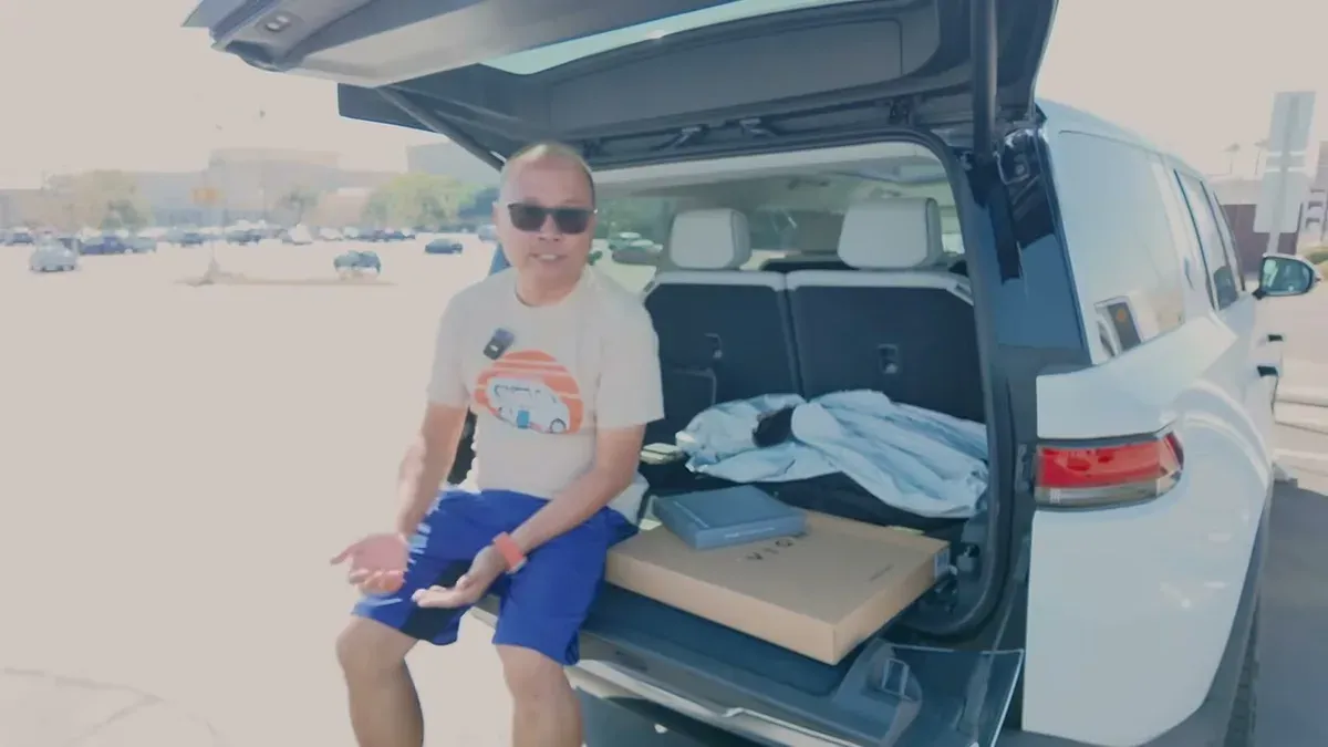 Man sitting on Rivian R1S tailgate with Vion products in trunk