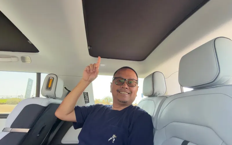 Sherwin in the Rivian R1S third row pointing up at the installed Vion roof shade
