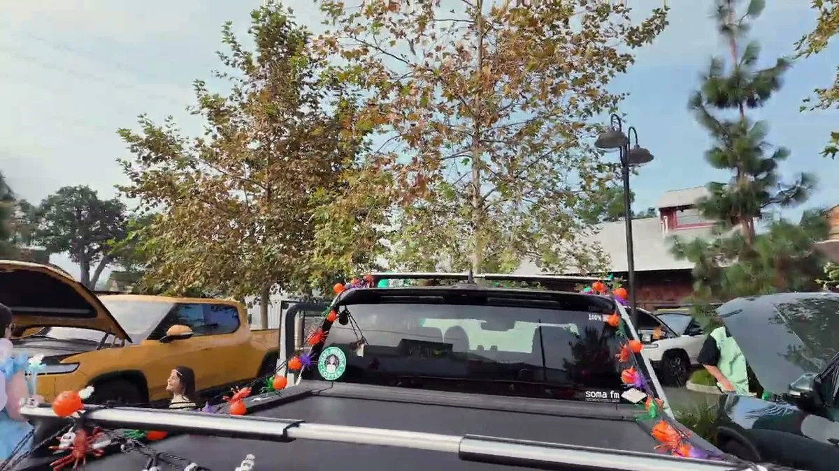 Black Rivian R1T truck bed decorated with spiders and orange Halloween lights