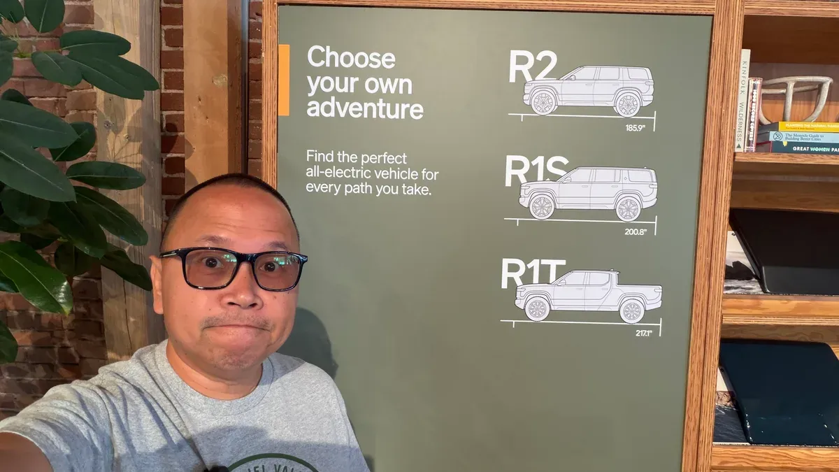 Sherwin at the Rivian Pasadena display board comparing R2, R1S, and R1T lengths