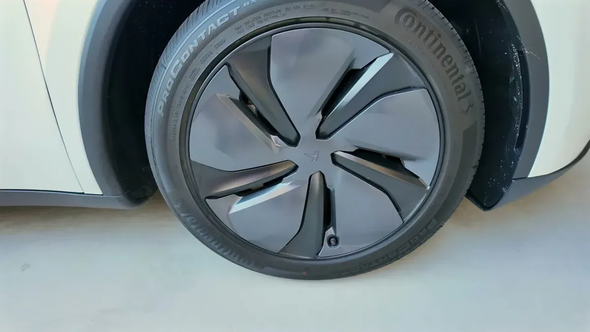 Close-up of a dark aero-style wheel with Continental tire on the Model Y Juniper