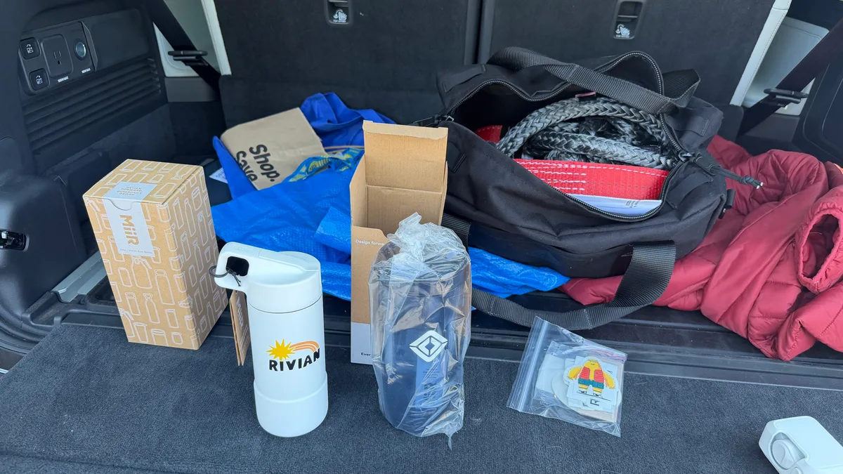 Meetup prize haul in the trunk: recovery gear duffel, Rivian MiiR water bottles, and a Gear Guard Gary sticker pack