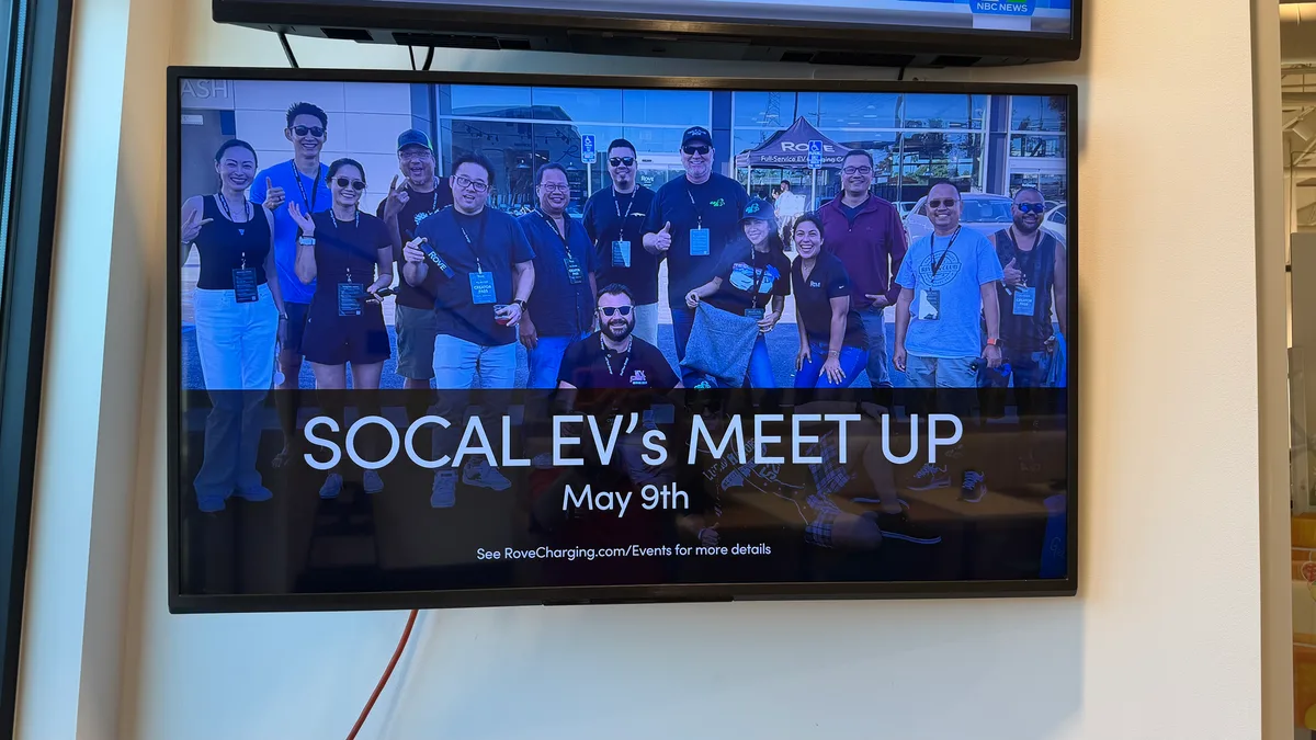 TV screen showing SoCal EV's Meetup event promotion at Rove Costa Mesa.
