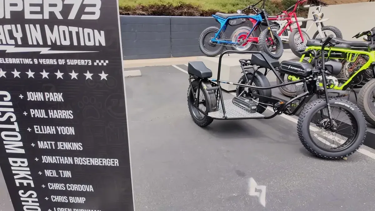 Custom Super73 electric bikes on display, including a black bike with a sidecar attachment, at an event.