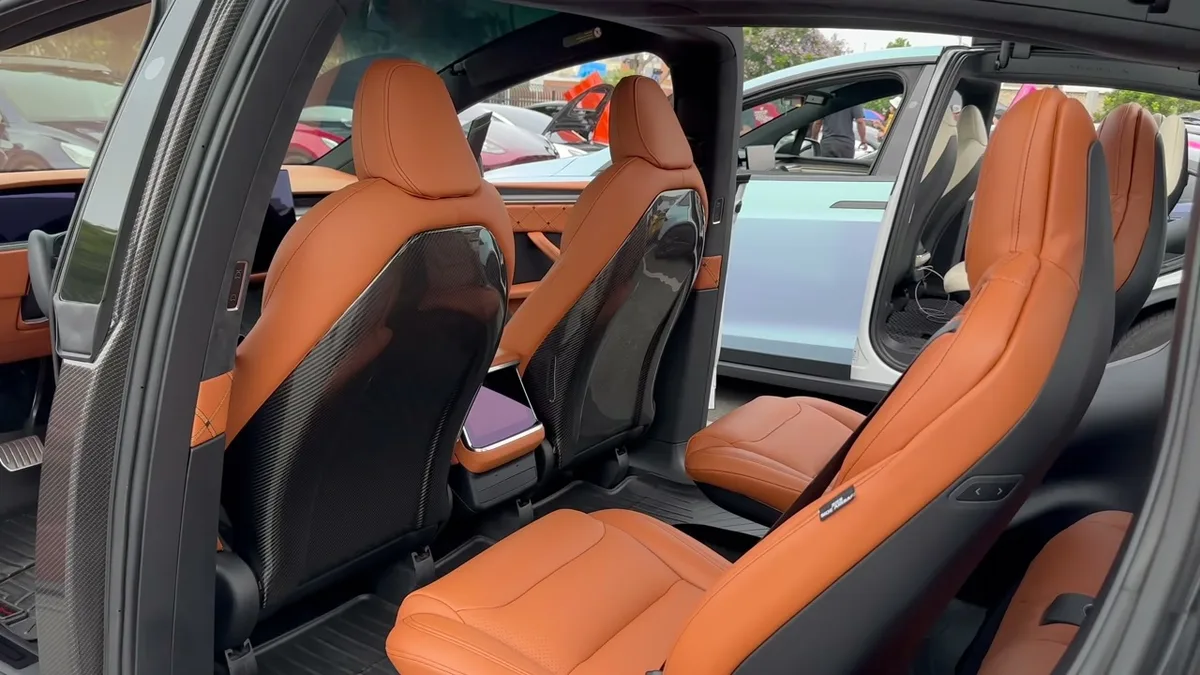 Rear interior of George's custom Model X showing quilted Nappa leather seats and carbon fiber accents