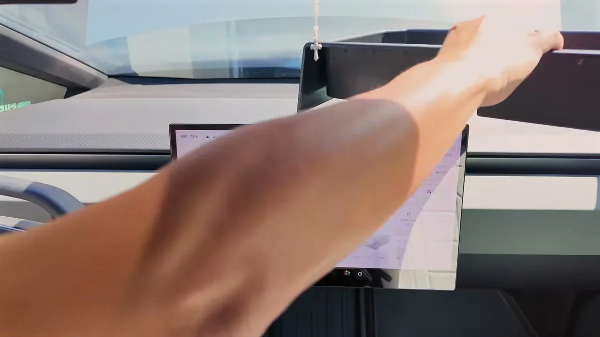 Arm installing the BestEVMod dash tray above the Cybertruck LCD screen