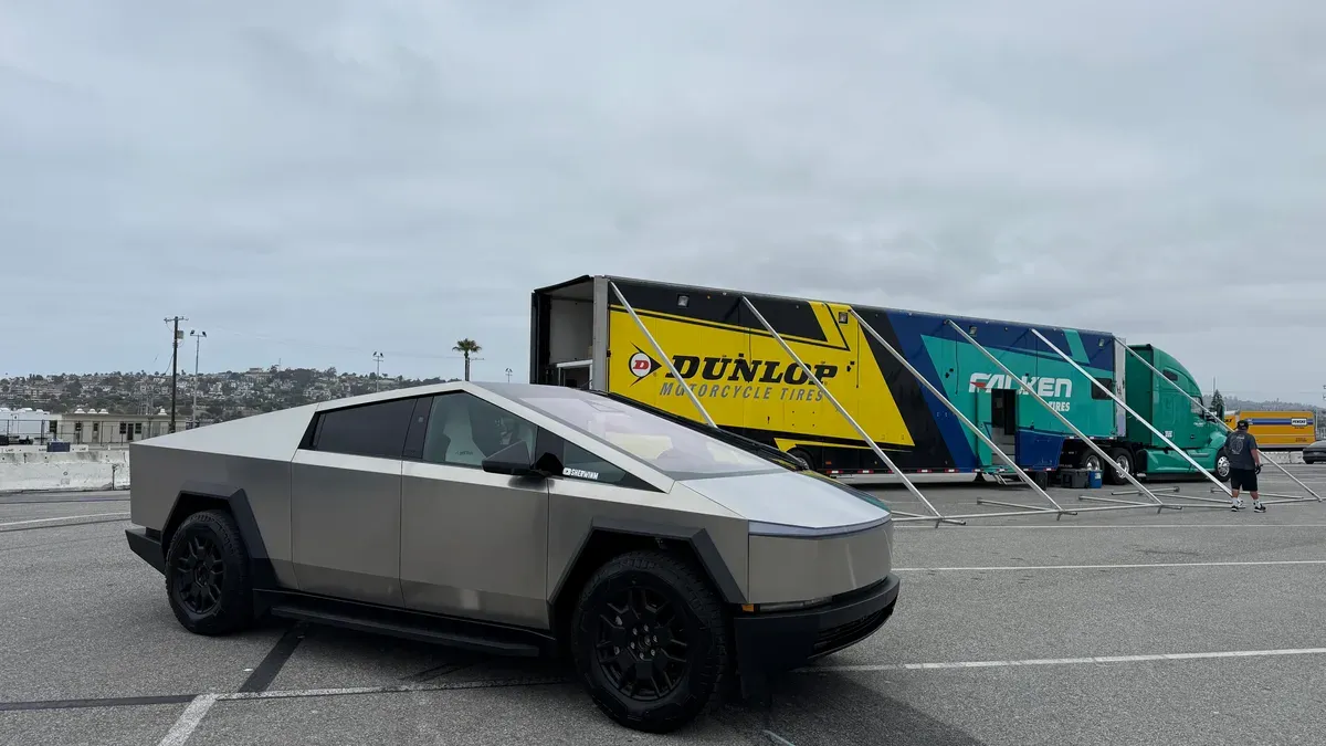 Tesla Cybertruck parked in front of a Dunlop and Falken tire trailer at the Electrify Expo venue at the Port of Los Angeles