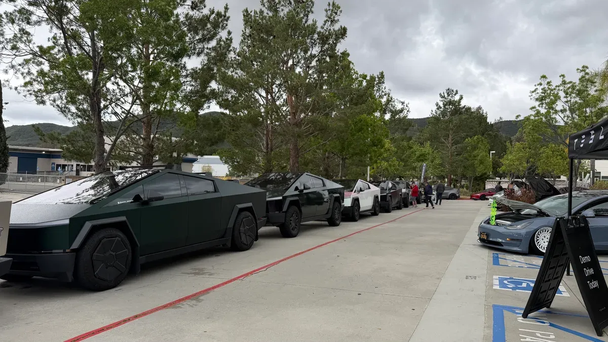 Long line of custom Cybertrucks in green, black, and white at the meet.