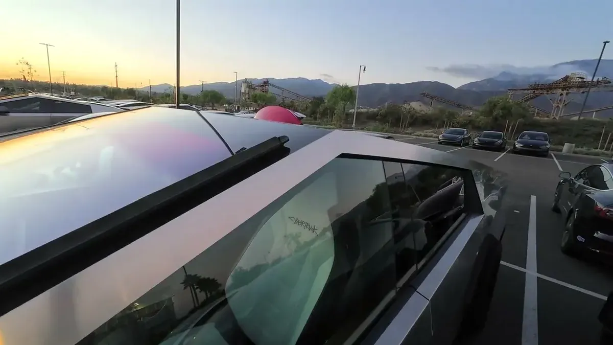 Overhead view of Tesla Cybertruck roof and windshield at Tesla Upland service center, mountains visible in background