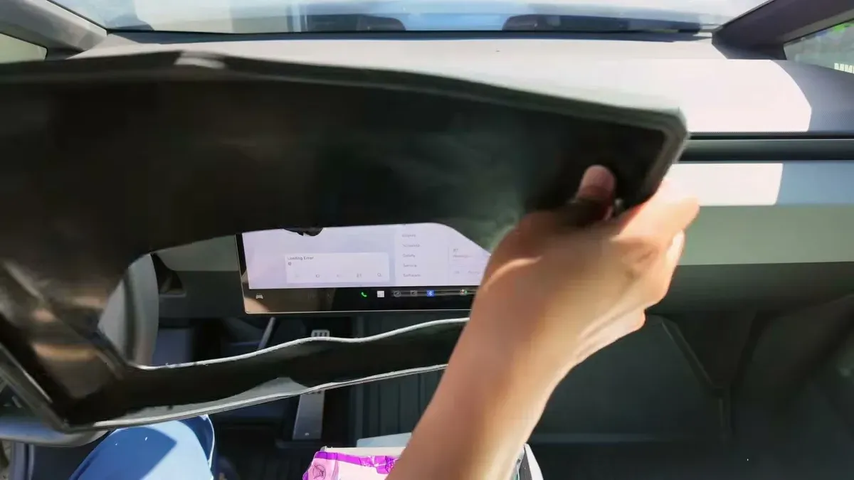 Hands fitting the BestEVMod LCD edge protector around the Tesla Cybertruck screen
