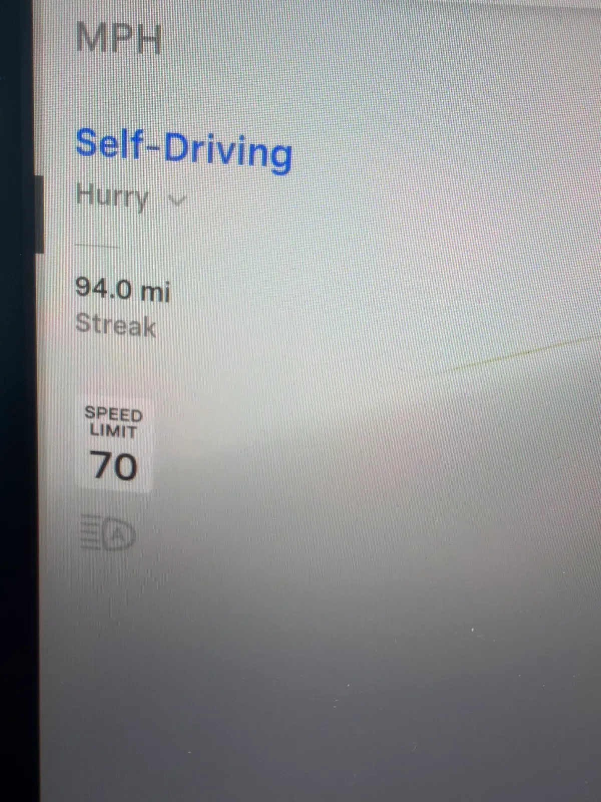 Tesla display showing a 94.0 mile Full Self-Driving streak approaching 100 miles