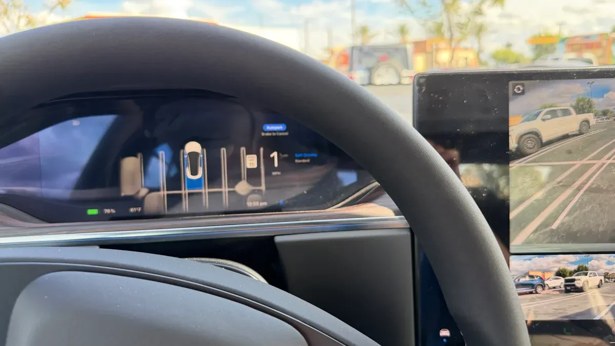 Tesla steering wheel and infotainment screen showing FSD visualization with turn camera and road view.