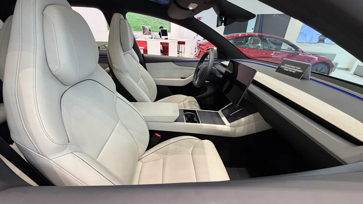Tesla Model YL dashboard, steering wheel, and central touchscreen in Zen Gray trim.