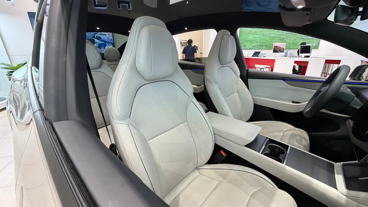 Light gray front seats inside the Tesla Model YL.
