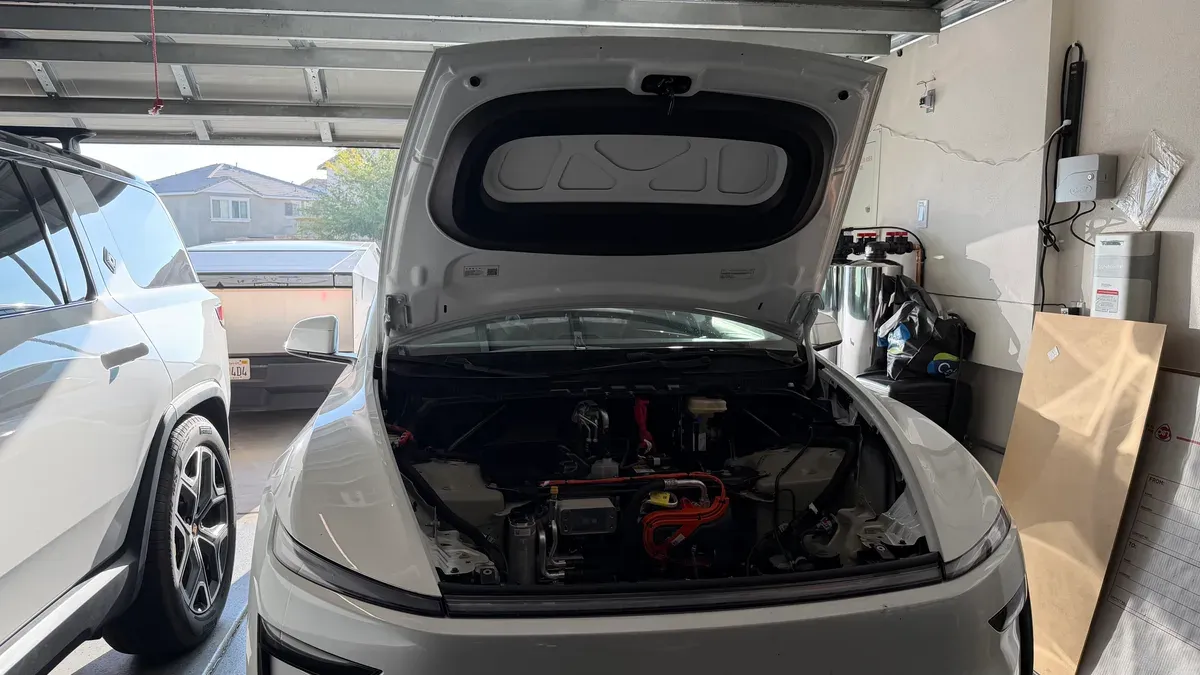 White Model Y Juniper with frunk open in garage showing install components