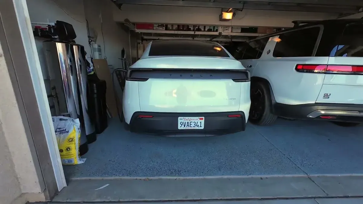 White Juniper and red Launch Series parked together in garage showing the badge differences on the rear