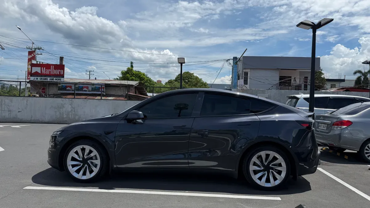 Side profile of Doc Dennis's Stealth Gray Tesla Model Y parked in Santa Cruz, Laguna