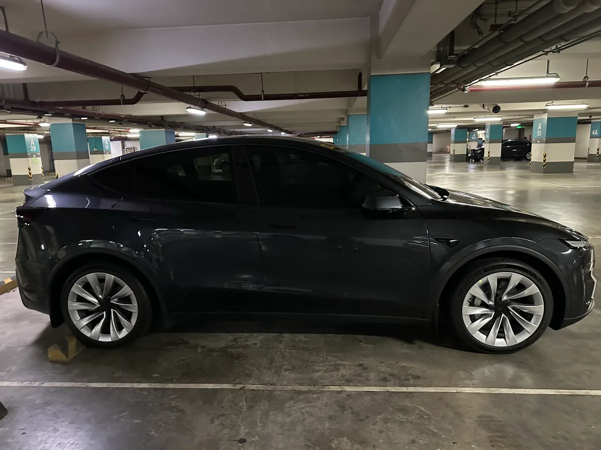 Side profile of a Stealth Gray Tesla Model Y parked in an underground garage in the Philippines