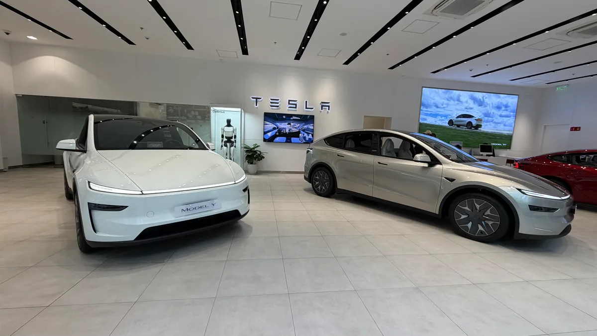 White and silver Tesla Model Y vehicles displayed inside the BGC Tesla showroom.