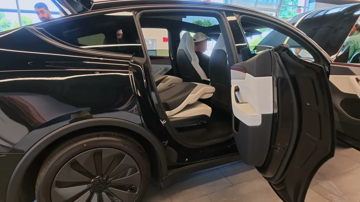 Rear door of the Tesla Model Y L opened to its widest point, showing the two-tone interior.