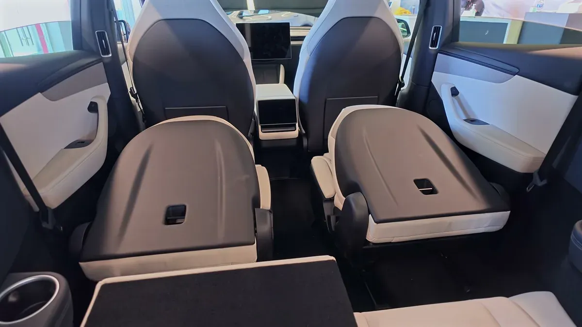 Model Y L second-row seats folded down, showing the step and gap in the load floor behind them.