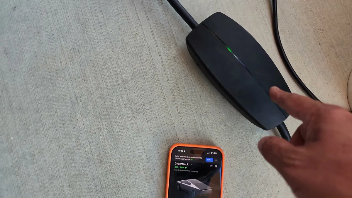 Gen 3 Mobile Connector showing a green light on the ground next to a phone running the Tesla app on the Cybertruck