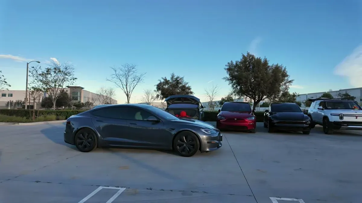 Tesla and Rivian lineup parked at dusk