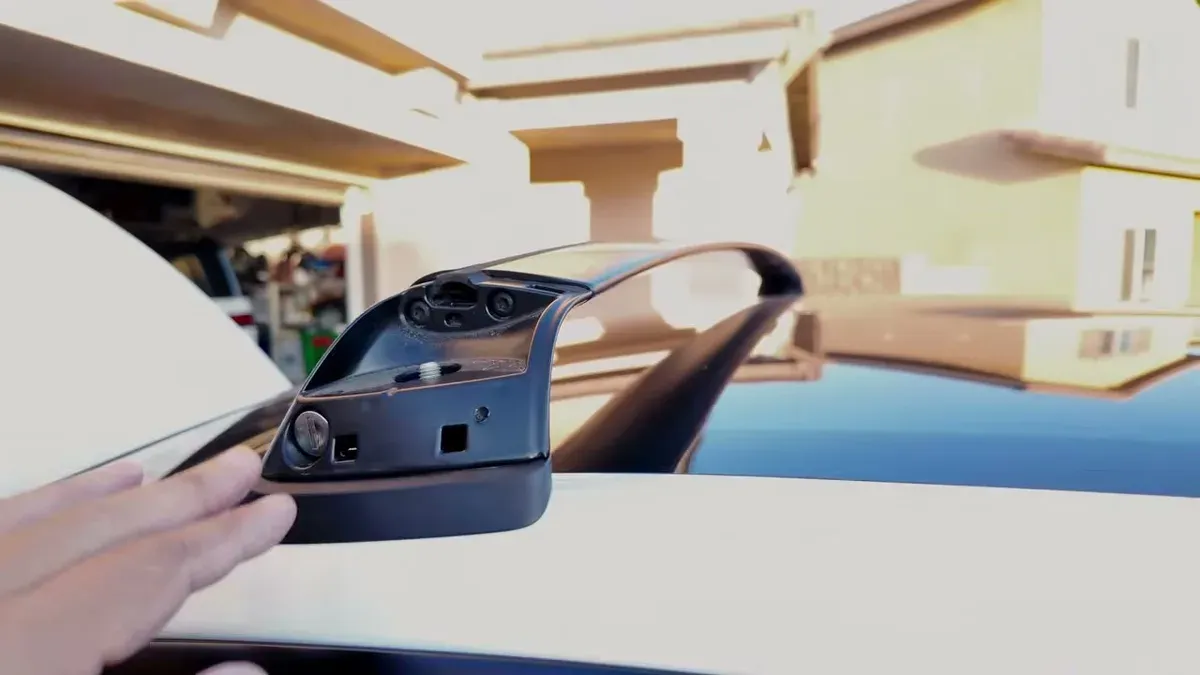 Close-up of the Tesla roof rack crossbar attachment point clipped onto the Model Y Juniper roof rail
