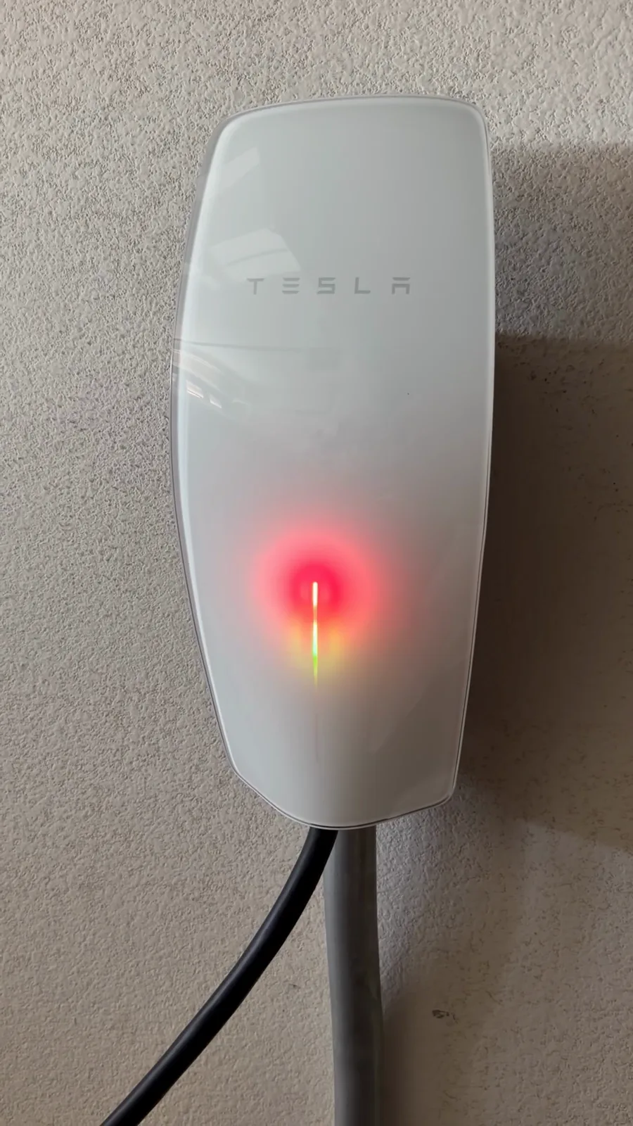 Tesla Wall Connector on the garage wall showing the three red fault lights
