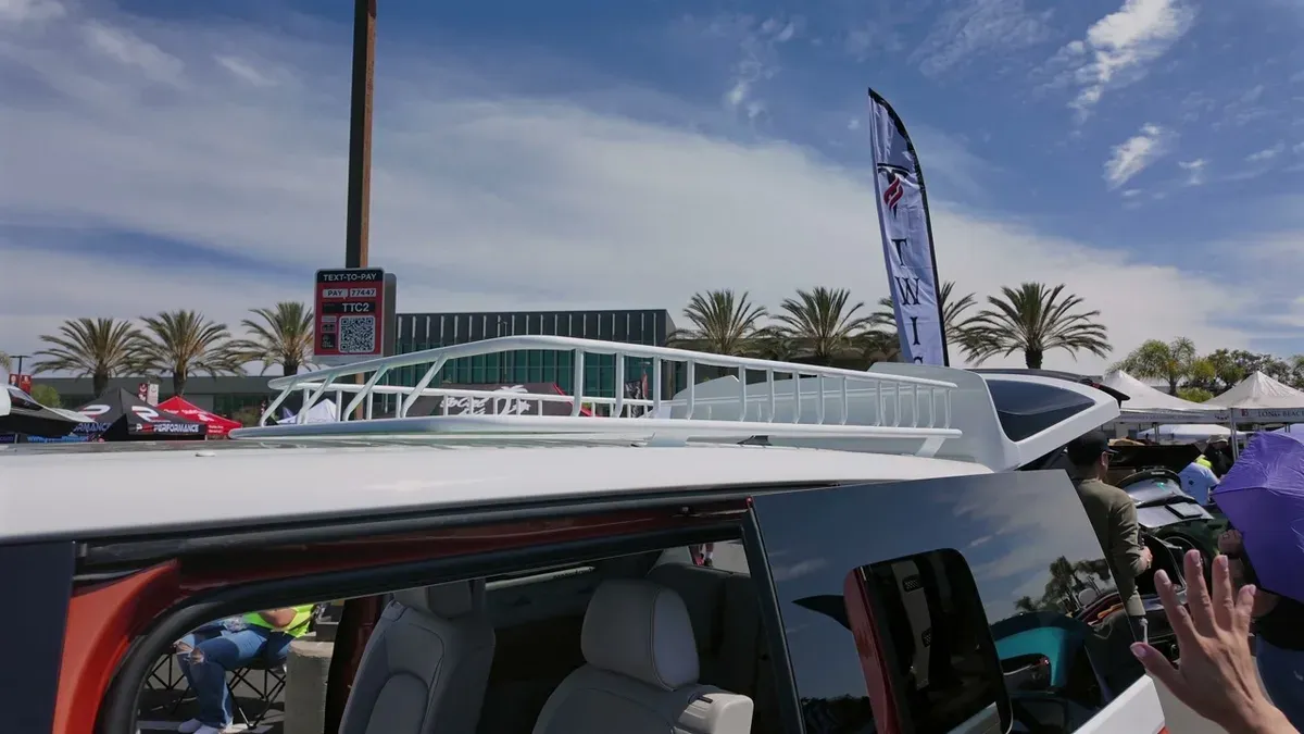Custom white roof rack on the VW ID. Buzz against a blue sky with palm trees