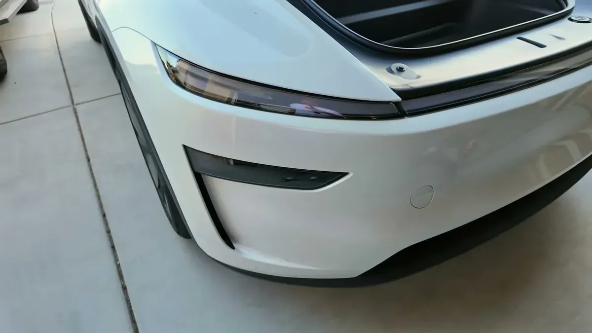 Close-up of the white Model Y Juniper front lower bumper showing the sequential light strip design
