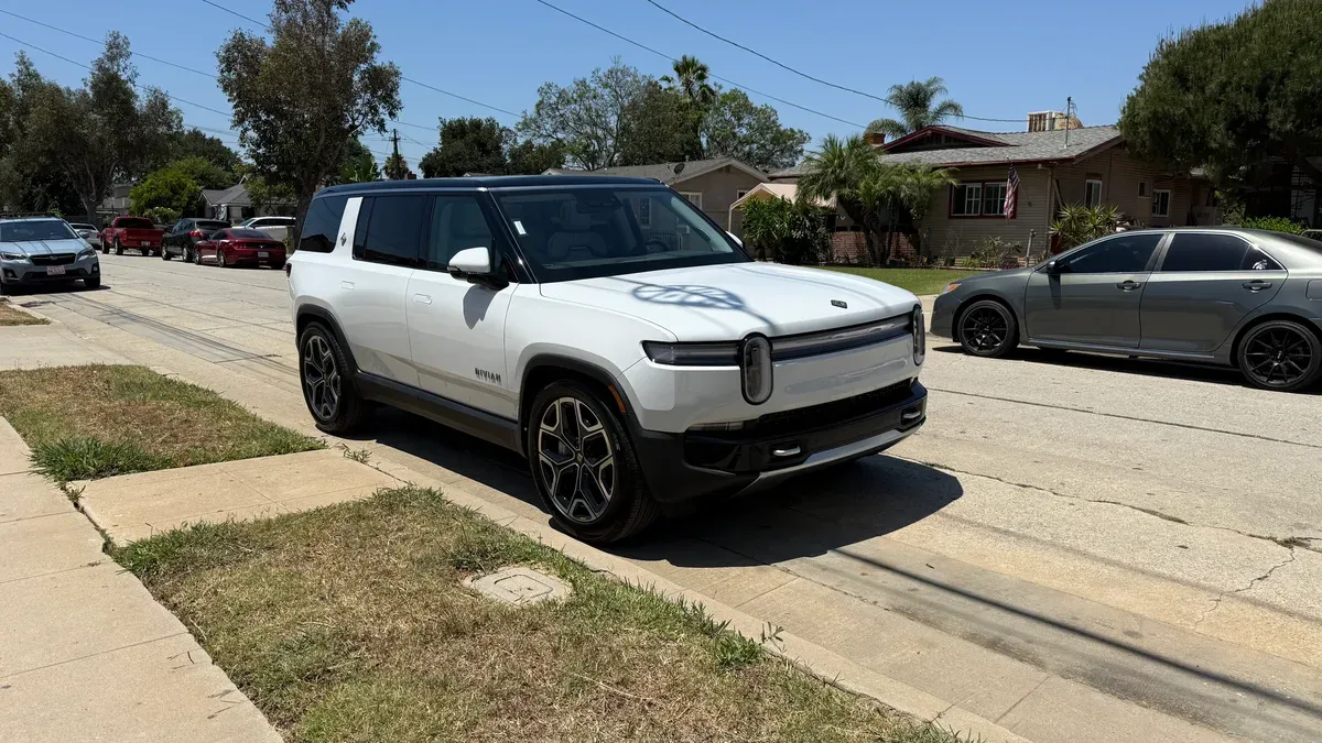 White Rivian R1S SUV parked on a sunny residential street in Southern California.